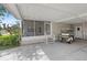Spacious carport with a golf cart, steps to a screened porch, and convenient side door access at 432 King Way, Tavares, FL 32778
