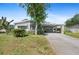 Charming single-story home with a covered carport and beautiful landscaping under a clear blue sky at 432 King Way, Tavares, FL 32778