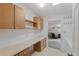 Efficient laundry area with counter space, and extra storage, adjacent to a home office area at 432 King Way, Tavares, FL 32778