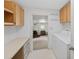 Practical laundry area with built-in cabinetry and convenient access to an office area at 432 King Way, Tavares, FL 32778