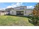 Spacious backyard featuring a covered patio, lush lawn, and a fun playset for children at 4515 Lions Gate Ave, Clermont, FL 34711