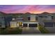 Beautiful two-story home with a two-car garage and professionally landscaped yard highlighted by a beautiful sunset at 4515 Lions Gate Ave, Clermont, FL 34711