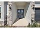 Inviting covered entryway featuring a double door, stone accents, and manicured landscaping at 4515 Lions Gate Ave, Clermont, FL 34711