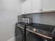 Modern laundry room features stylish black Samsung washer and dryer with white cabinets at 4515 Lions Gate Ave, Clermont, FL 34711