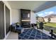 Covered outdoor patio with an electric fireplace, comfortable seating, and a view of the backyard at 4515 Lions Gate Ave, Clermont, FL 34711