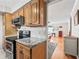 Well-lit kitchen with stainless steel appliances, granite countertops, and wood cabinets flowing into the adjacent living space at 500 Newell Hill Rd # 111A, Leesburg, FL 34748