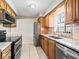 Bright kitchen featuring stainless steel appliances, granite countertops, and wood cabinets with a tile backsplash at 500 Newell Hill Rd # 111A, Leesburg, FL 34748
