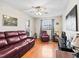 Cozy living room featuring a plush burgundy sofa, hardwood floors, and a ceiling fan with lighting at 500 Newell Hill Rd # 111A, Leesburg, FL 34748