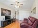 This living room has a burgundy sofa, hardwood floors, closet, and a modern entertainment center at 500 Newell Hill Rd # 111A, Leesburg, FL 34748