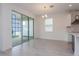 Bright dining area with sliding glass doors and modern lighting fixtures, adjacent to the kitchen at 5024 Balsam Falls Rd, Deland, FL 32724