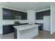 Modern kitchen with stainless steel appliances, quartz countertops, and dark cabinetry at 5028 Balsam Falls Rd, Deland, FL 32724