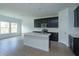 Well-lit kitchen featuring an island with a sink, dark cabinets, and stainless steel appliances at 5028 Balsam Falls Rd, Deland, FL 32724