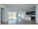 Open-concept living space with wood-look tile, flowing into the kitchen, and sliding door access to outdoors at 5028 Balsam Falls Rd, Deland, FL 32724