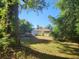 Large backyard features a lawn, foliage, and a view of the home's screened porch at 5029 Eagles Nest Rd, Fruitland Park, FL 34731