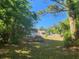 Lush backyard features a well-maintained lawn, mature trees, and a glimpse of the house at 5029 Eagles Nest Rd, Fruitland Park, FL 34731