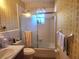 Bathroom showcasing a shower-tub combination with a glass sliding door and tiled walls at 5029 Eagles Nest Rd, Fruitland Park, FL 34731