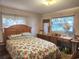 Cozy bedroom features a floral comforter and natural light from the window at 5029 Eagles Nest Rd, Fruitland Park, FL 34731