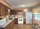 Spacious kitchen featuring wood cabinets and white appliances with patterned floor at 5029 Eagles Nest Rd, Fruitland Park, FL 34731