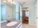 Bright bathroom showcasing a vanity sink and a view into the adjacent bedroom with a floral comforter at 508 Carrera Dr, The Villages, FL 32159