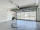 Spacious garage with epoxy flooring and a large automatic overhead garage door allowing natural light at 508 Carrera Dr, The Villages, FL 32159