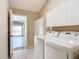 Laundry room with a side-by-side washer and dryer and ample storage cabinets at 508 Carrera Dr, The Villages, FL 32159