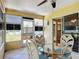Enclosed porch showcasing a glass table with wicker chairs, offering a cozy and inviting outdoor space at 508 Carrera Dr, The Villages, FL 32159