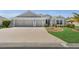Charming home featuring a three-car garage and well-maintained lawn and landscaping at 5220 Horsford Path, The Villages, FL 32163
