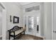 Inviting foyer with a bench, decorative mirror, and stylish lighting, creating a warm entry space at 5220 Horsford Path, The Villages, FL 32163