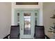 Welcoming front porch with seating, highlighting the decorative glass front door at 5220 Horsford Path, The Villages, FL 32163