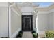Elegant front entrance featuring a security door and manicured landscaping for a welcoming arrival at 5220 Horsford Path, The Villages, FL 32163
