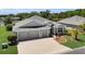 Beautiful home with a well-kept lawn, three-car garage, and decorative landscaping, offering curb appeal at 5220 Horsford Path, The Villages, FL 32163