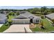 Charming single-story home featuring a manicured lawn, three-car garage, and a picturesque pond view at 5220 Horsford Path, The Villages, FL 32163