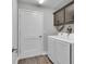 Laundry room with modern washer, dryer, and convenient overhead cabinet storage at 5220 Horsford Path, The Villages, FL 32163