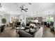 Open-concept living area with dining table, sofas, and bar stools in kitchen at 5220 Horsford Path, The Villages, FL 32163