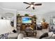 Comfortable living room featuring a built-in entertainment center, fireplace, and plush sofas at 5220 Horsford Path, The Villages, FL 32163