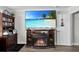 A living room featuring a large TV on a decorative stand with a fireplace and built-in storage at 5220 Horsford Path, The Villages, FL 32163