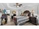 Main bedroom with stylish decor, tray ceilings, and wood-look floors at 5220 Horsford Path, The Villages, FL 32163