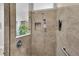The shower has tan tiled walls, a shower niche, and glass at 5220 Horsford Path, The Villages, FL 32163