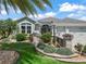 Beautiful single-story home with an expansive, landscaped front yard, colorful flowerbeds, and a paver driveway at 575 Wheelock St, The Villages, FL 32163