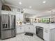 Modern kitchen with stainless steel appliances, white cabinets, quartz countertops, and an open layout at 575 Wheelock St, The Villages, FL 32163