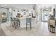 Bright, open kitchen with a breakfast bar, pendant lighting, tile flooring, and seamless flow to living spaces at 575 Wheelock St, The Villages, FL 32163