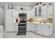 Modern kitchen showcasing white cabinets, stainless steel appliances, stylish backsplash, and ample counter space at 575 Wheelock St, The Villages, FL 32163