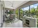 Enclosed lanai with patio seating, stylish decor, and views of the lush backyard at 575 Wheelock St, The Villages, FL 32163