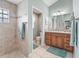 Well-lit bathroom with tiled shower, granite countertops, modern vanity and toilet at 575 Wheelock St, The Villages, FL 32163