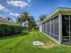 Well-maintained backyard with lush green lawn and screened-in porch, perfect for outdoor relaxation and entertaining at 633 Jameston Ave, The Villages, FL 32162
