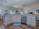 Open kitchen design with stainless steel dishwasher and breakfast bar overlooking the living area at 633 Jameston Ave, The Villages, FL 32162