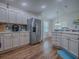 Spacious kitchen featuring stainless steel refrigerator, white cabinets, and adjacent breakfast nook at 633 Jameston Ave, The Villages, FL 32162