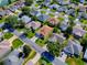 A peaceful neighborhood is captured from above, showing the proximity between houses and tree-lined streets at 633 Jameston Ave, The Villages, FL 32162