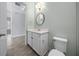 Bathroom featuring a white vanity with countertop, a round mirror and a toilet with silver fixtures at 677 Brooks Field Dr, Winter Garden, FL 34787