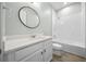 Clean bathroom with a white vanity, round mirror and a tub/shower combo, offering a functional space at 677 Brooks Field Dr, Winter Garden, FL 34787